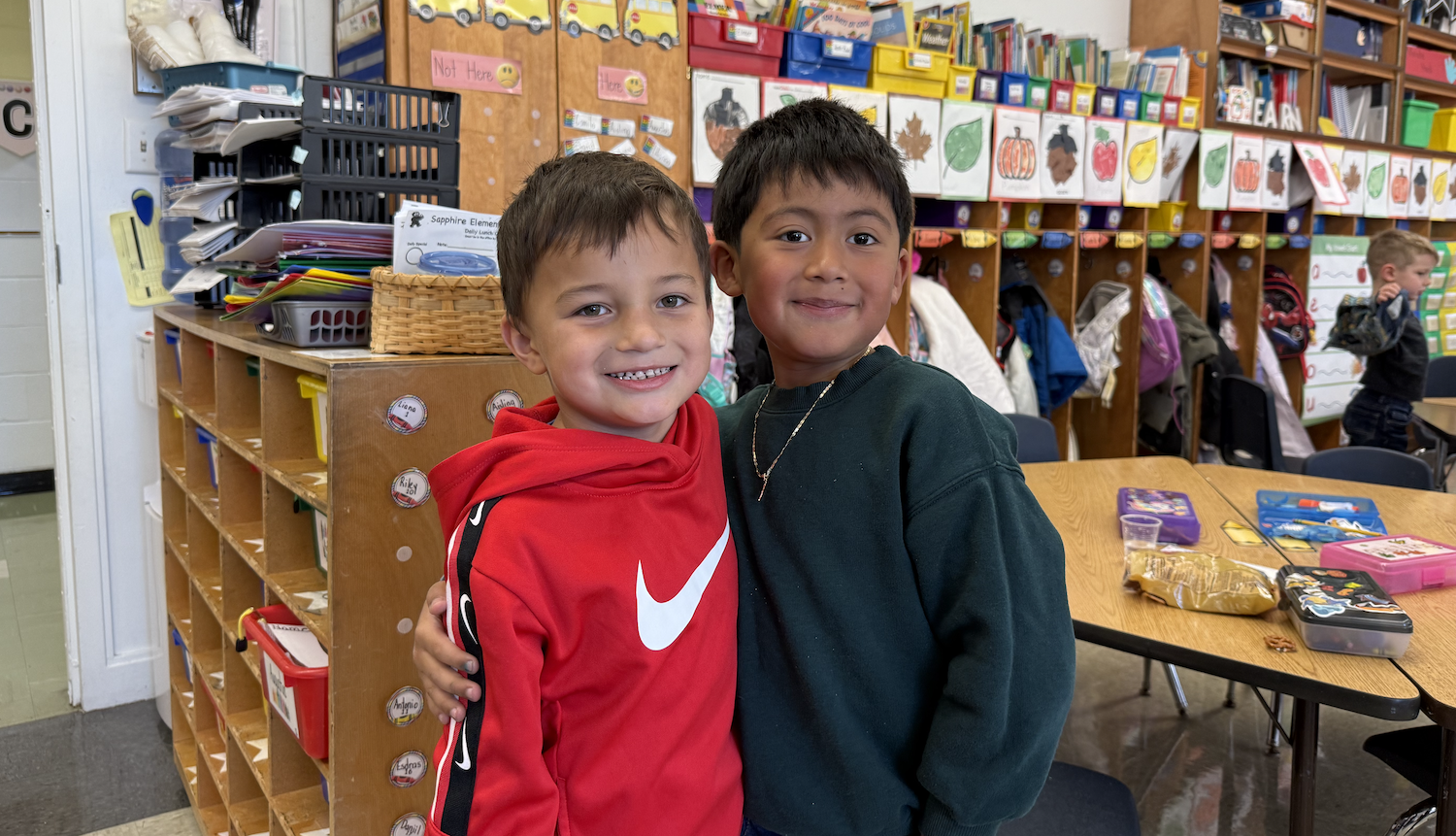 two boys wearing red and green sweatshirts
