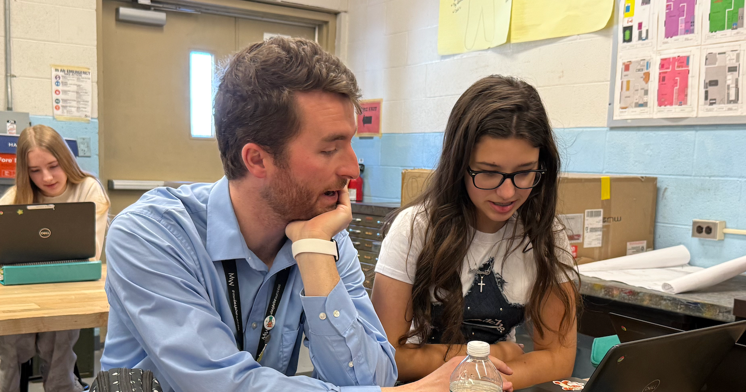 man and woman sitting at desk with computer
