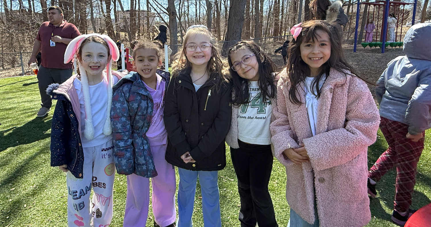 four students standing outside