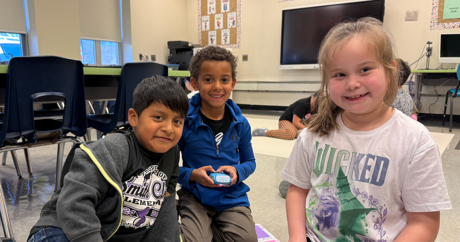 three students sitting with colorful flat blocks