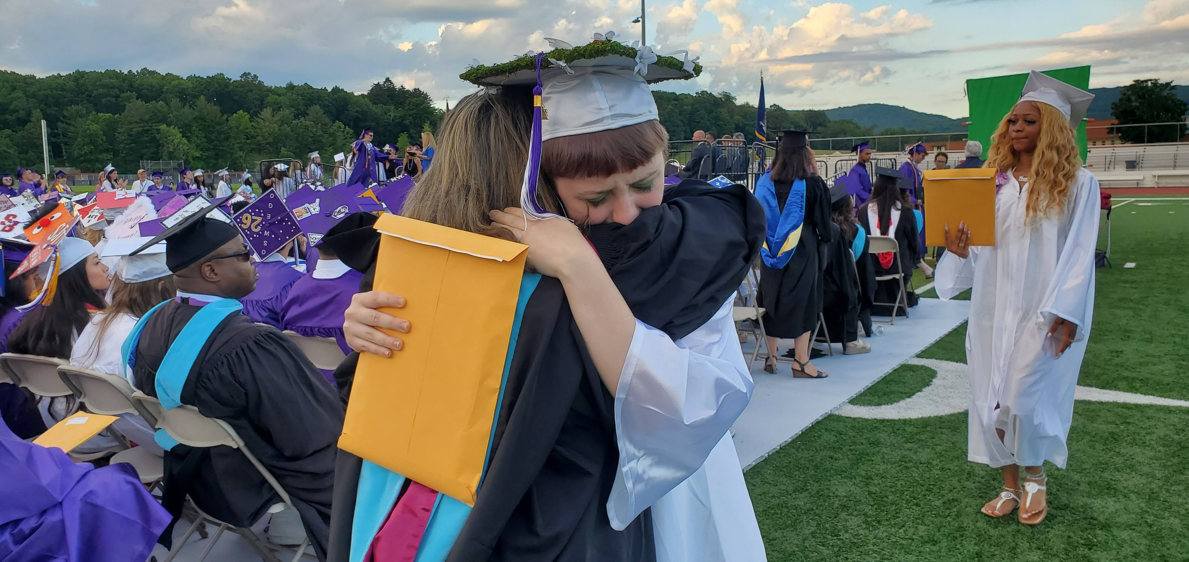 student with faculty at graduation