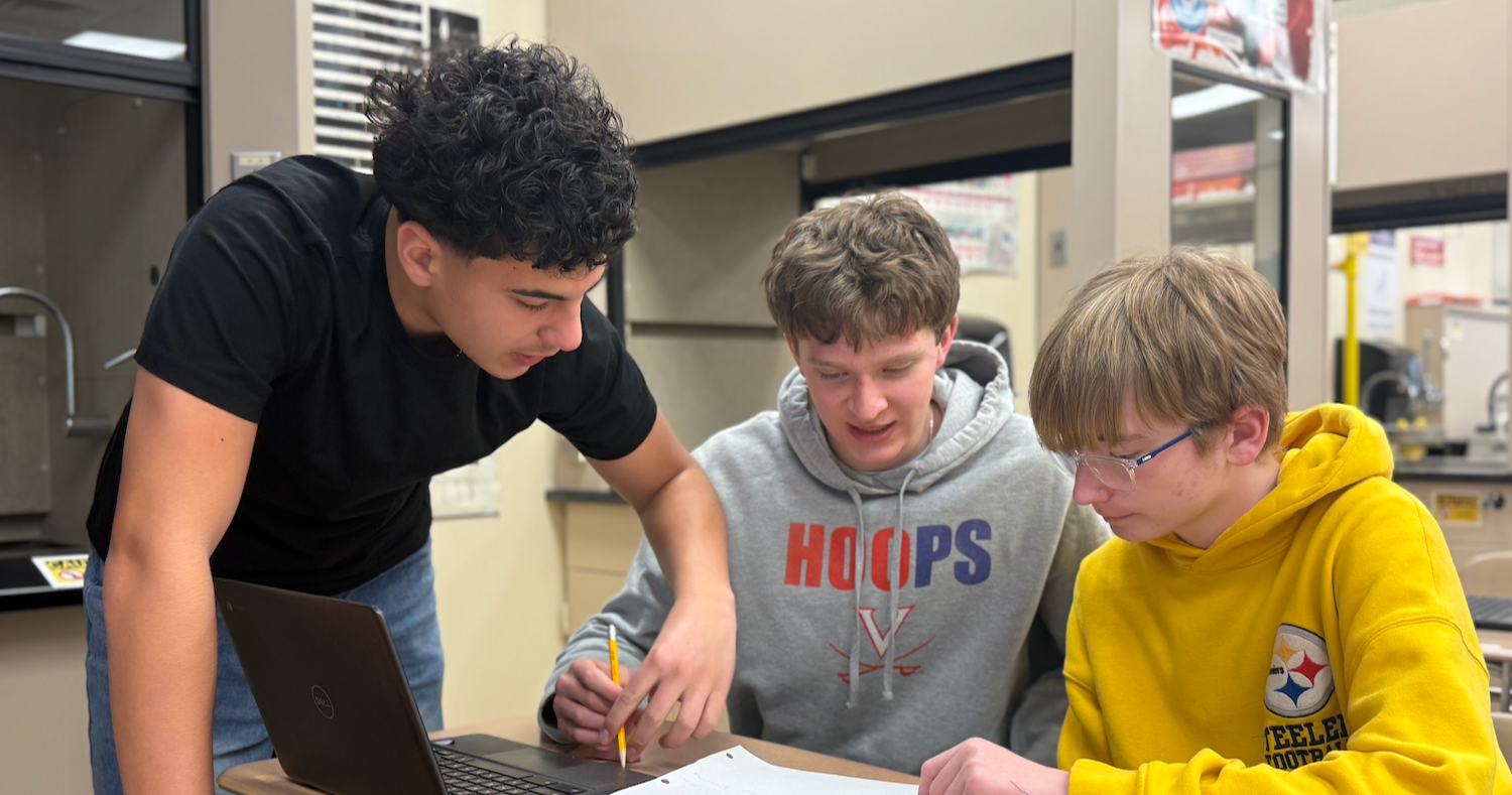three students sitting at desk