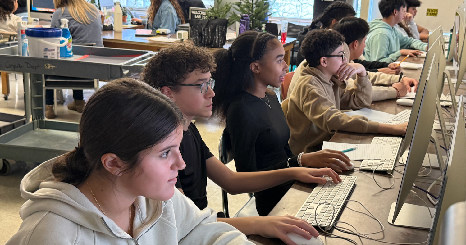 students typing on their computer