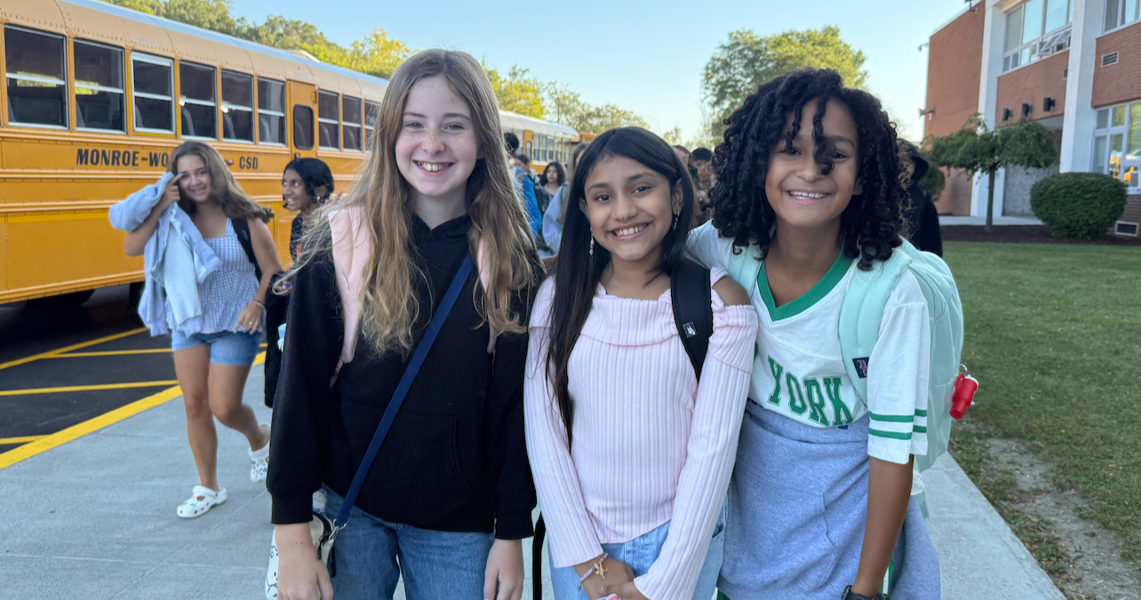 three students with backpacks and jean pants