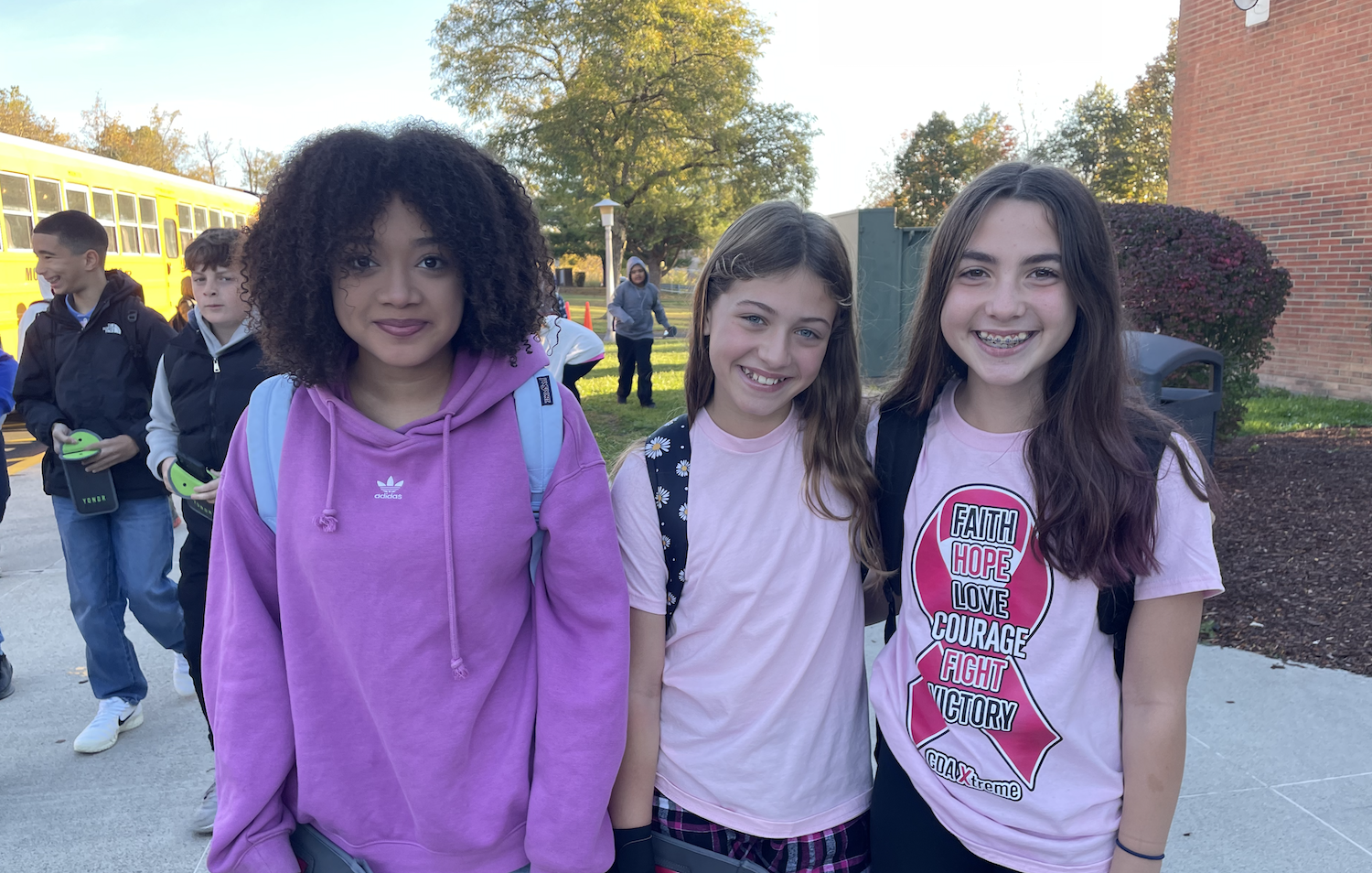 three students wearing pink shirts