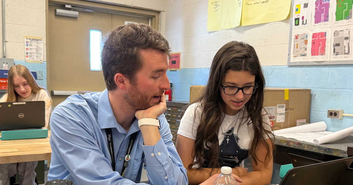 man with blue shirt and girl sitting at computer desk