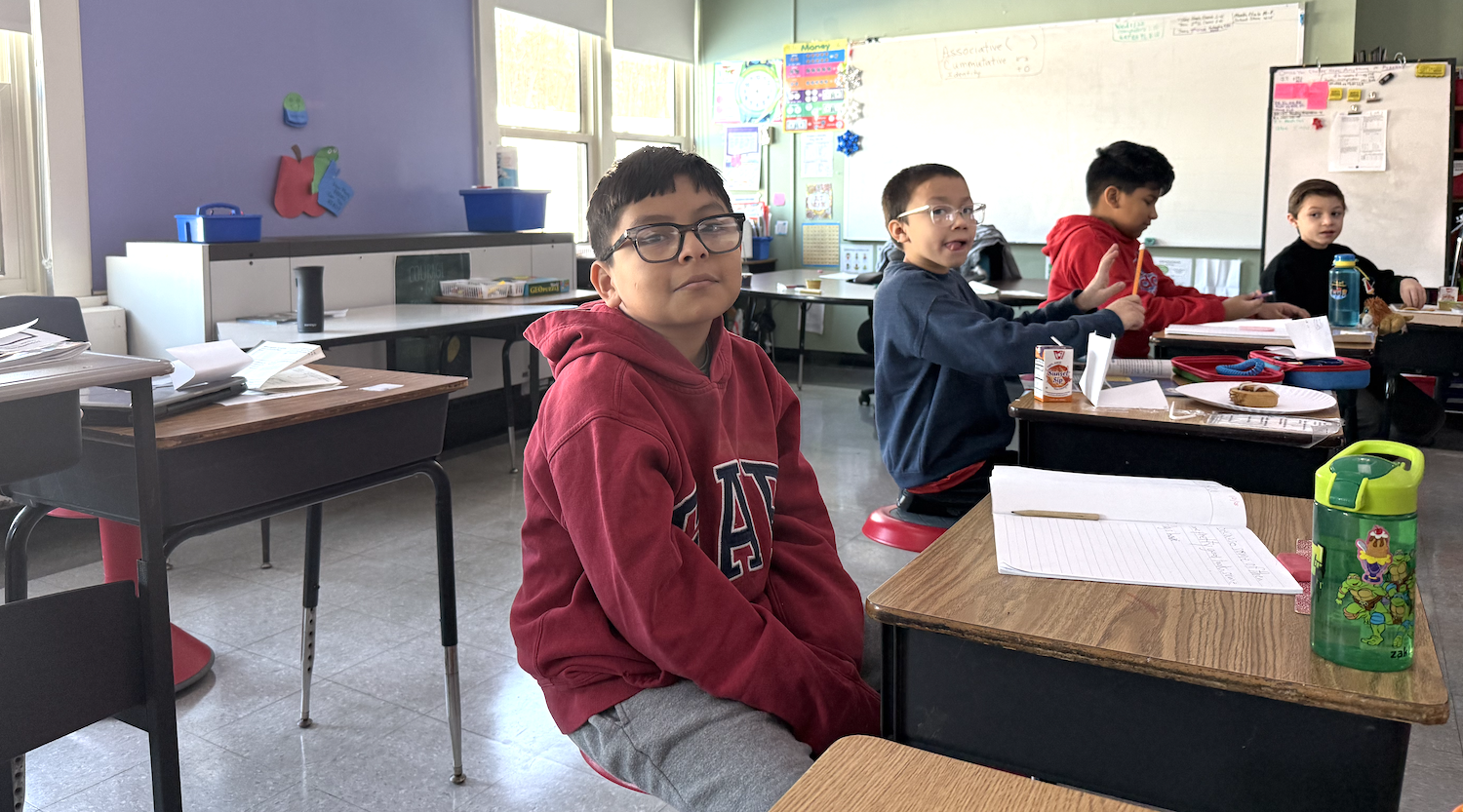 student with red shirt sitting in classroom 