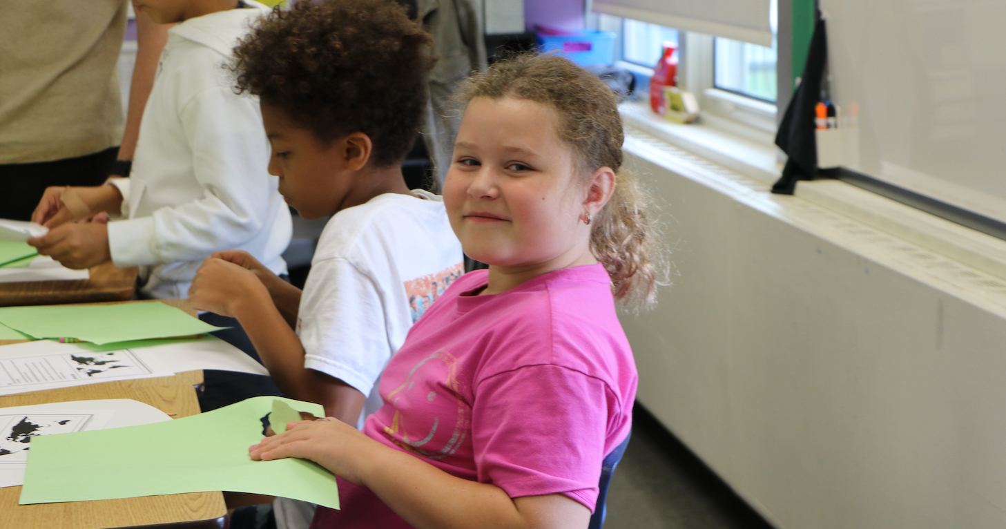 girl with pink shirt sitting in class