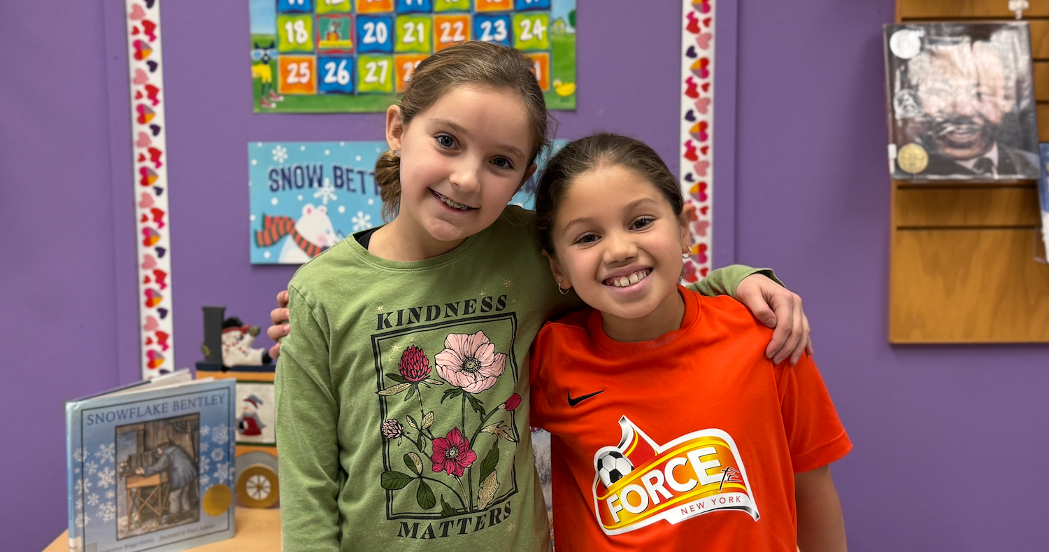 two girls standing in library