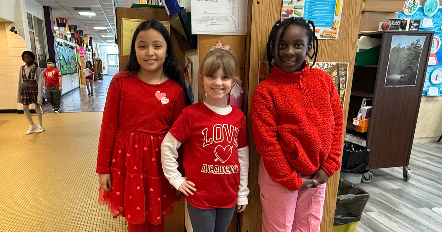 three students wearing red shirts and pants