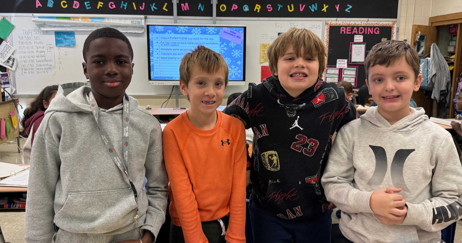 four students standing in class