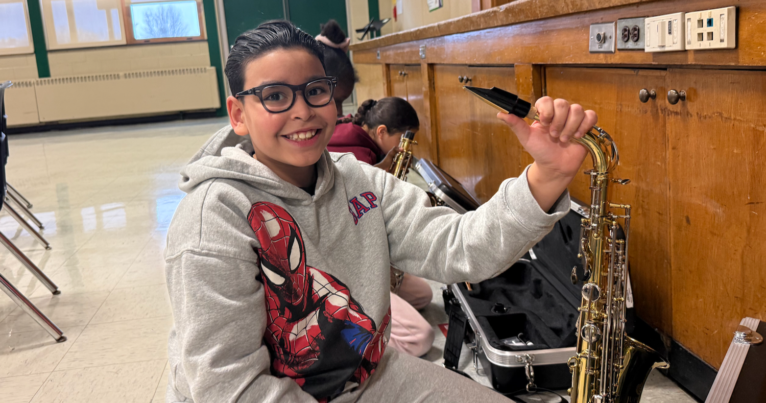 student holding saxophone music instrument
