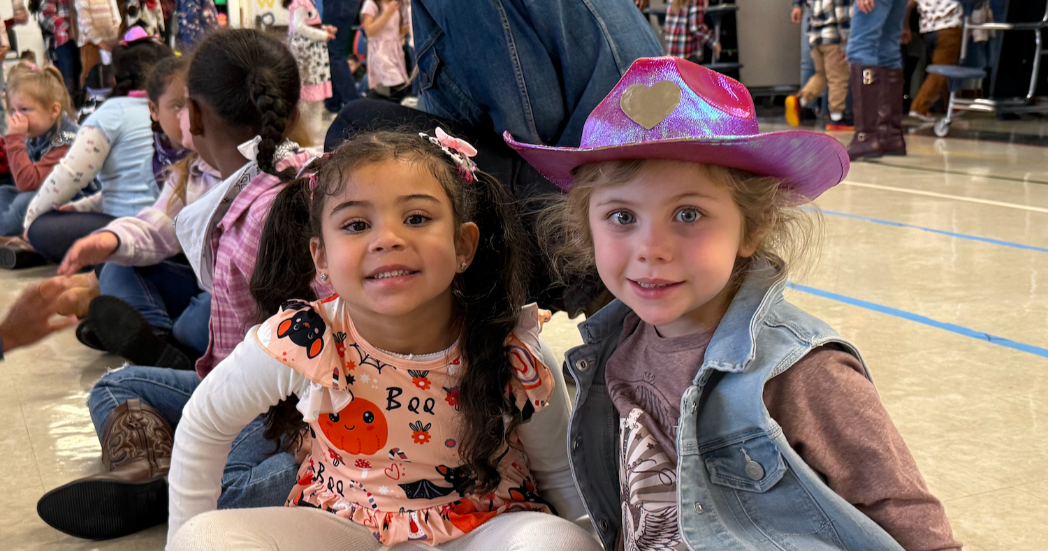 two students with cowboy hats and scarves