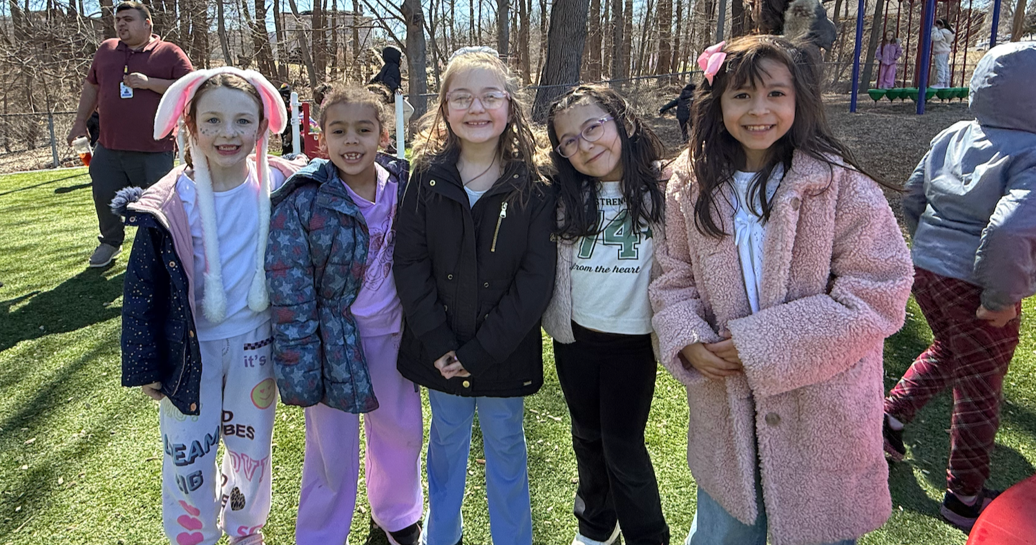 five students standing outside