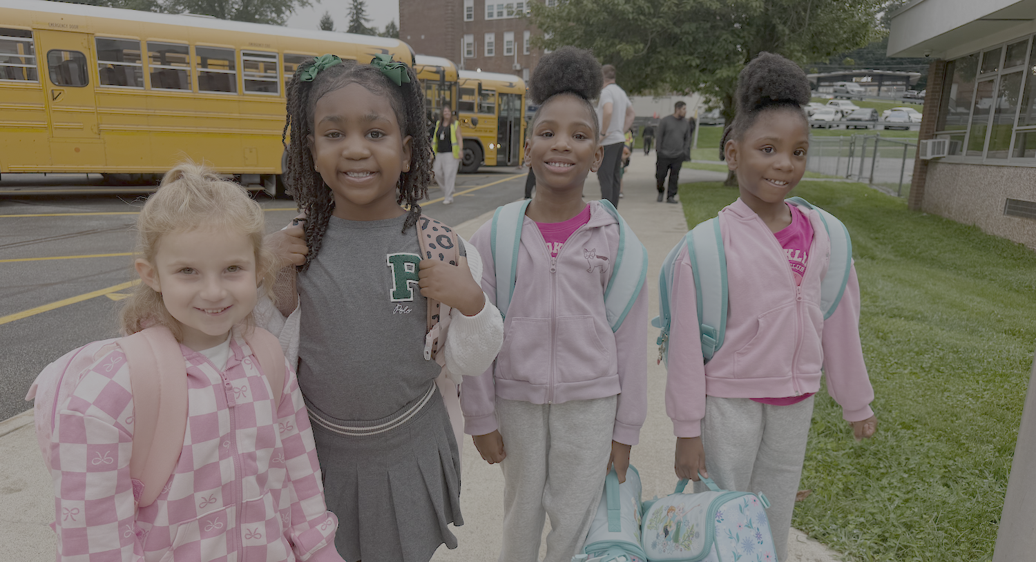 students with lunchboxes and backpacks on first day of school