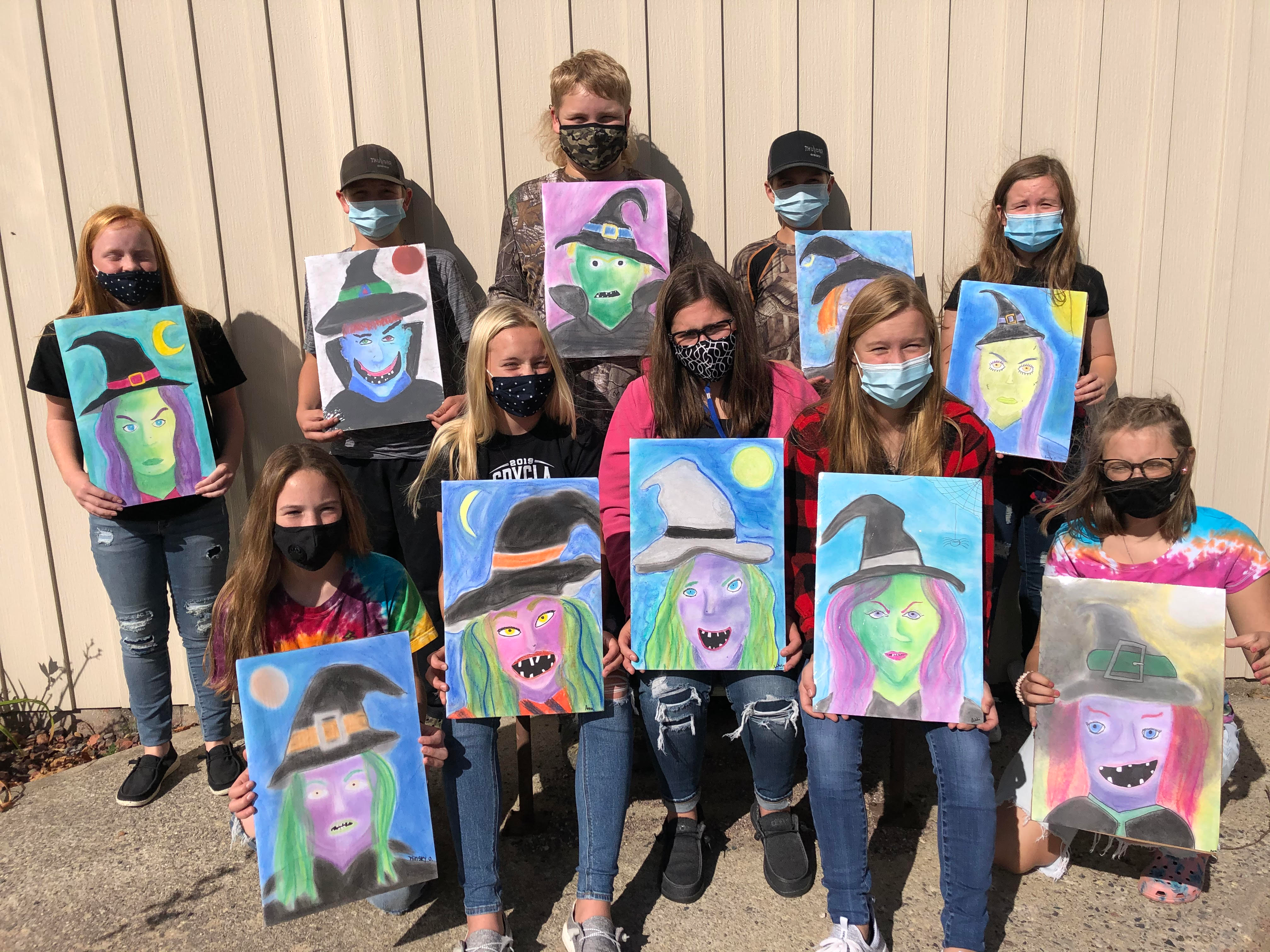 8th graders with their chalk drawings of witches