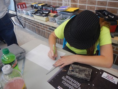 A photo of a student writing on a paper.