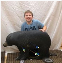 A photo of a student with a bear used as a target.