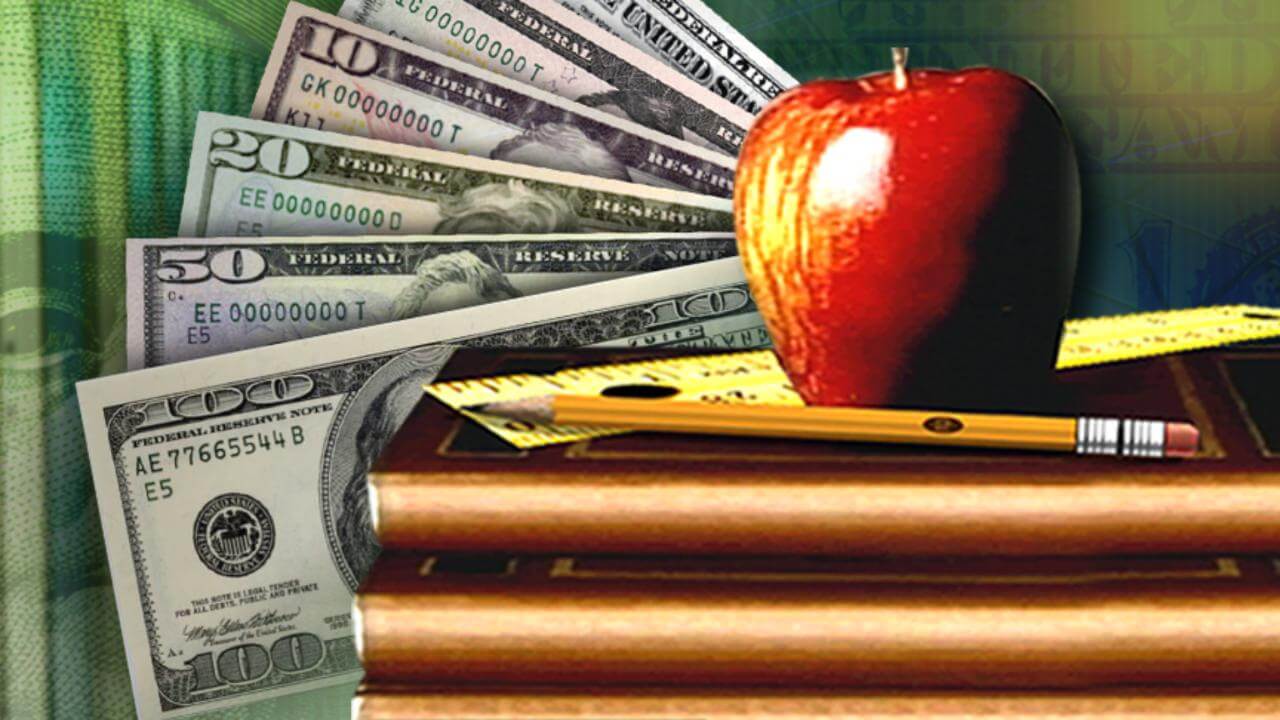 Books and apple with money behind them