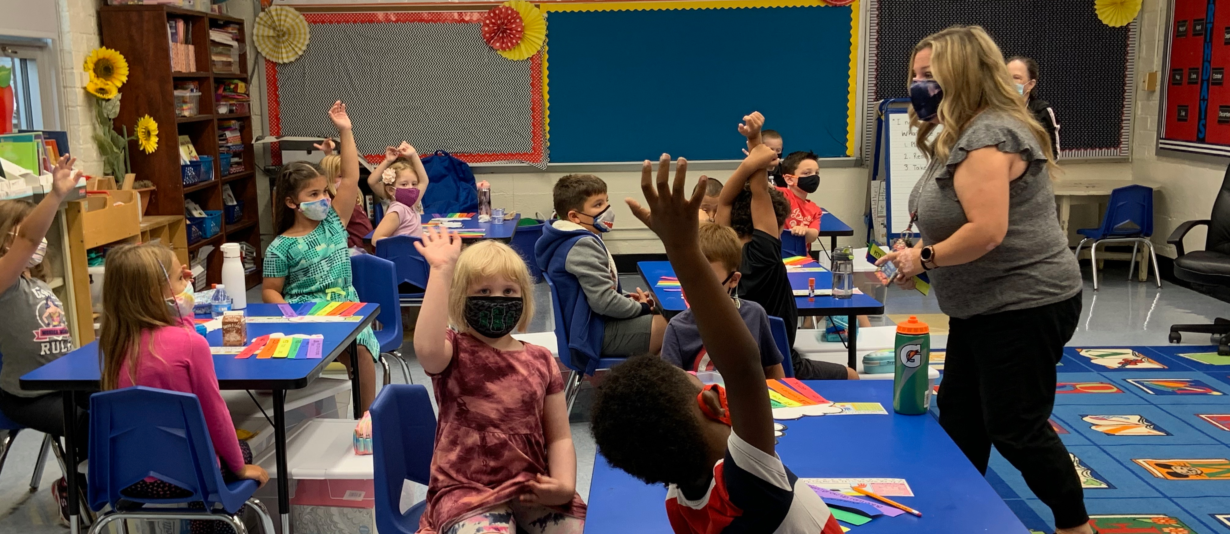 Children with Raised Hands in a classroom. 