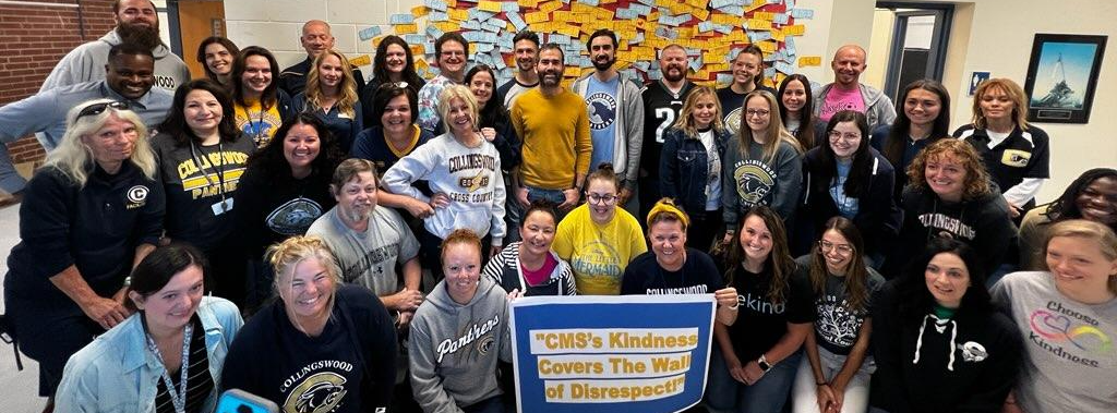 Staff from CMS pose with Week of Respect Sign that says "CMS Kindness covers the wall of disrespect" 