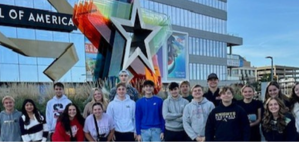 Group of High School Students taking a picture in front of Mall of America with the big multi-colored star sign.