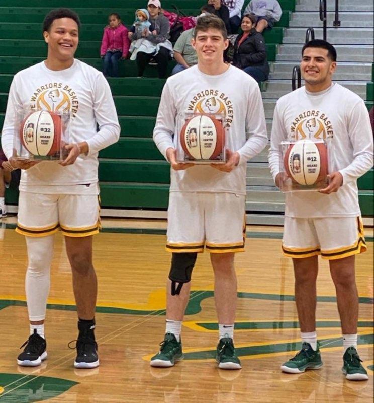 3 players holding basketballs under glass