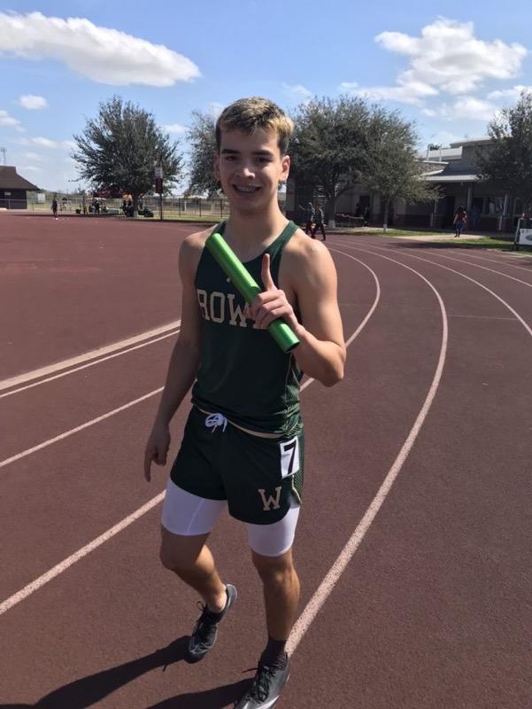 Track student holding baton for photo