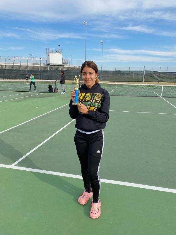 Female student holding a trophy on the court