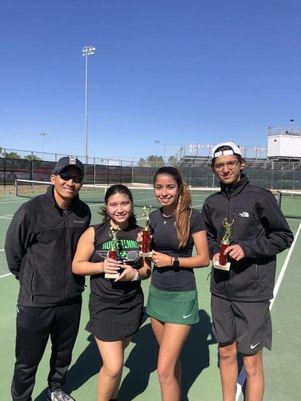 3 students holding trophies with coach