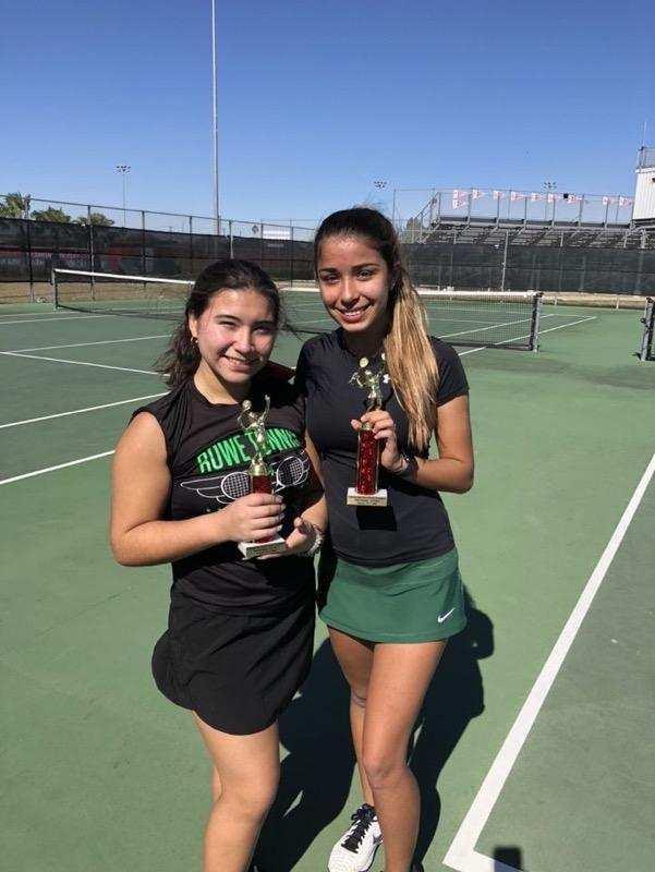 2 female students holding trophies