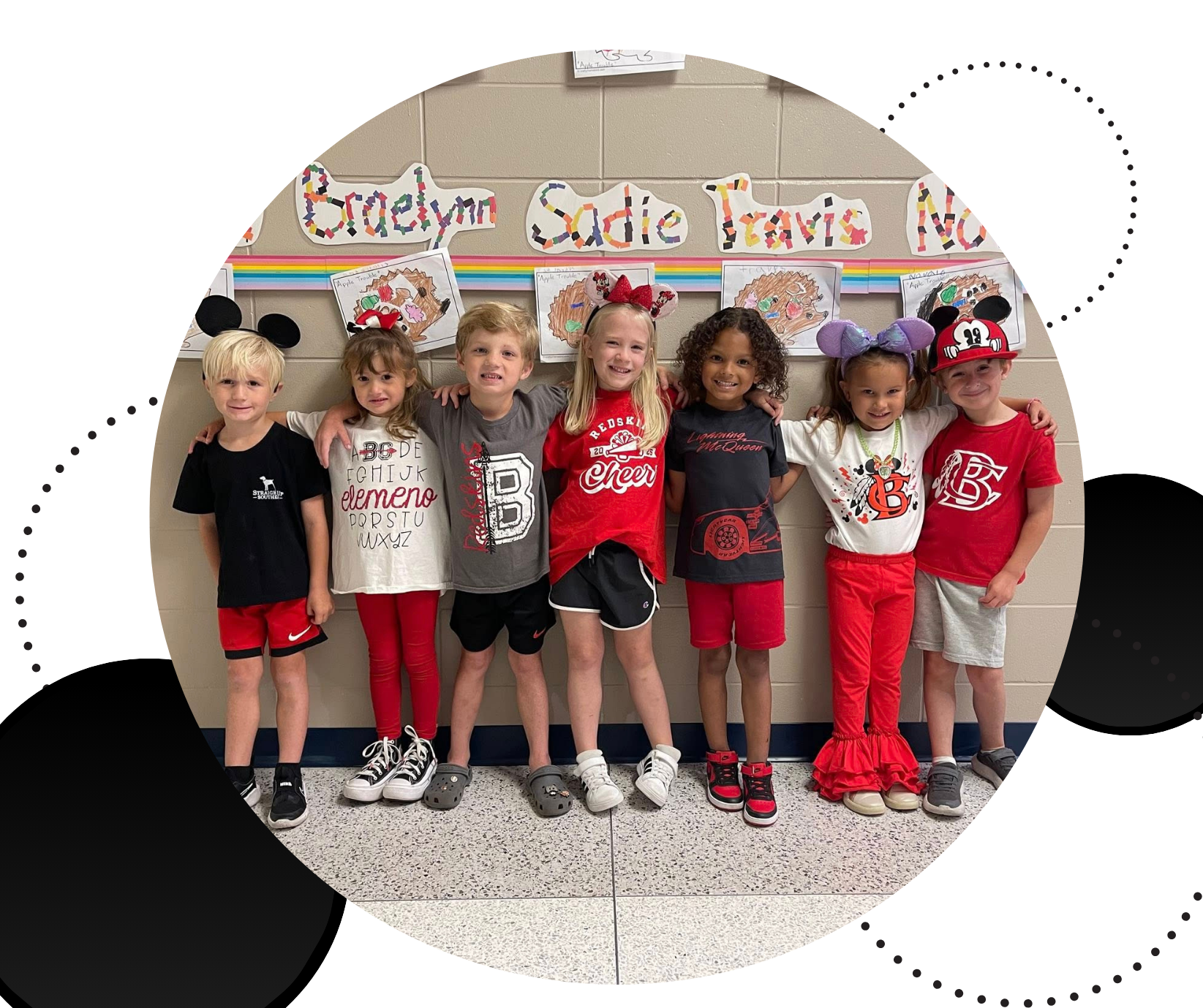 Kids standing in a row with arms around each other against a wall