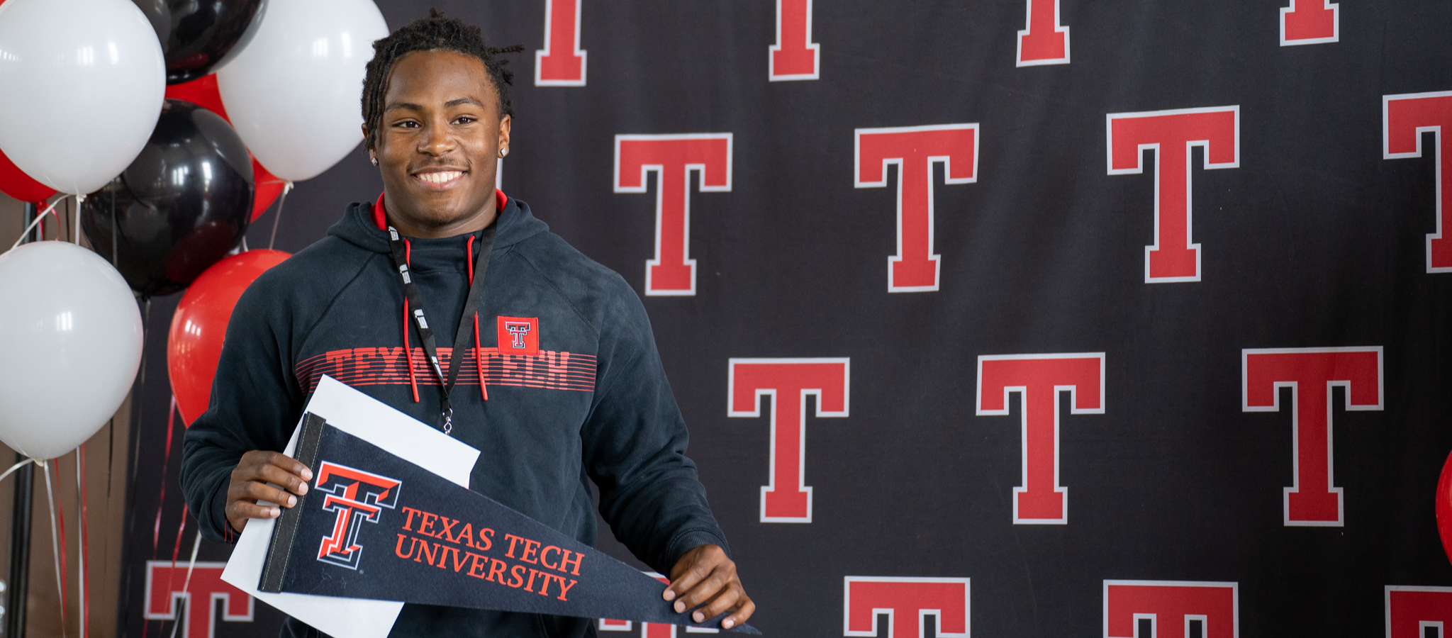 student holding Texas Tech pennant