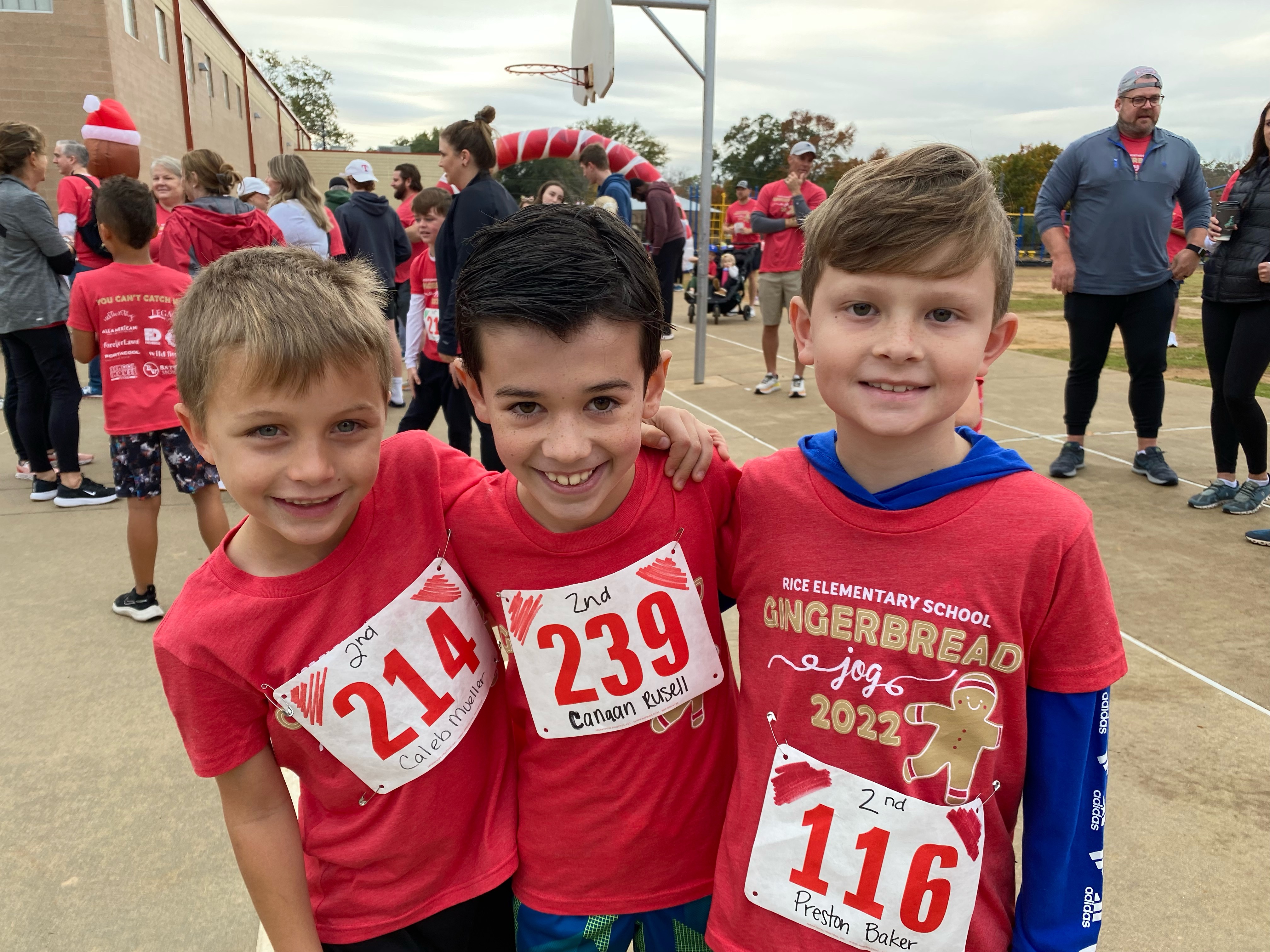 three elementary age boys wearing red shirts standing next to each other