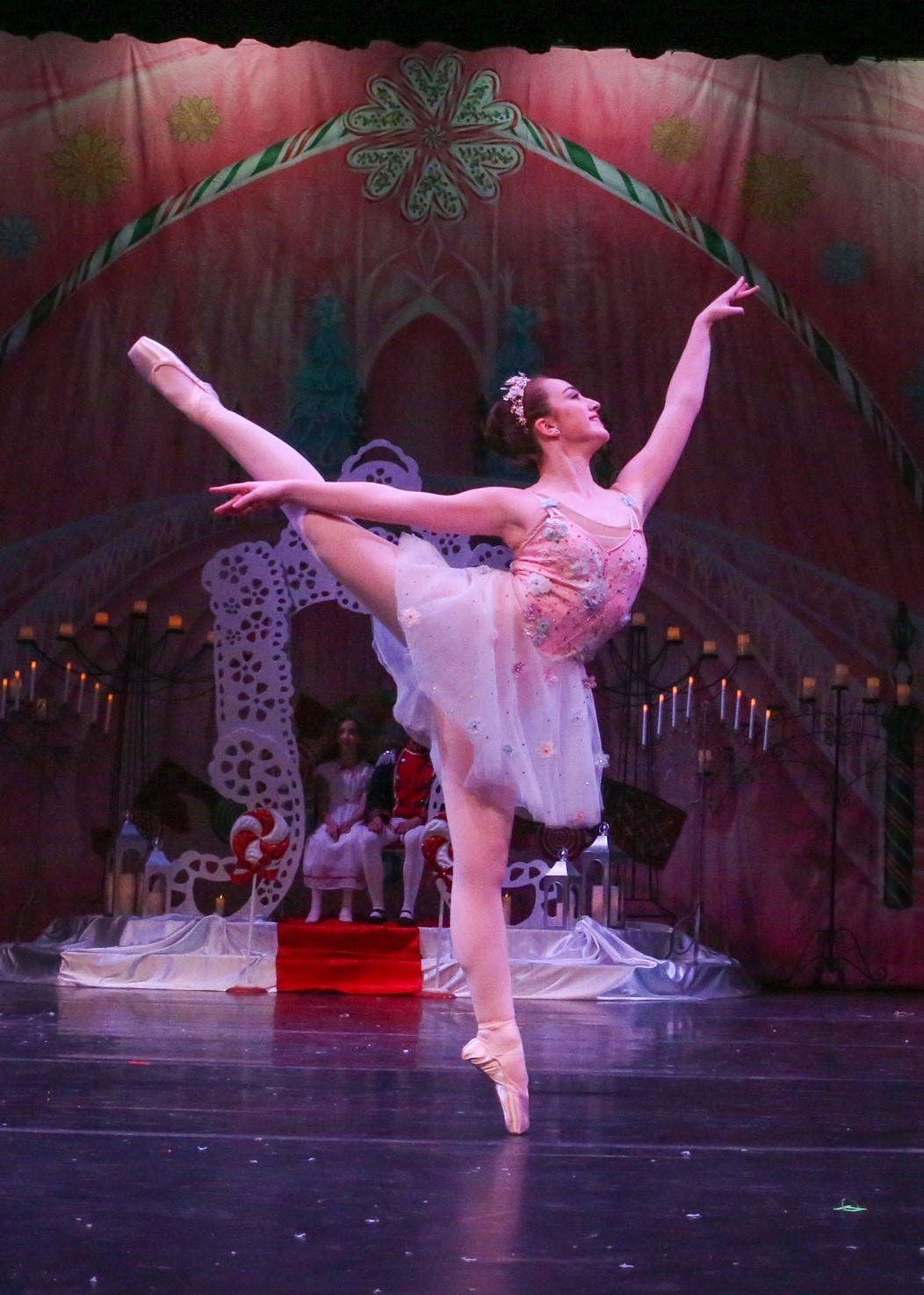 teenage girl in ballet costume with leg in air