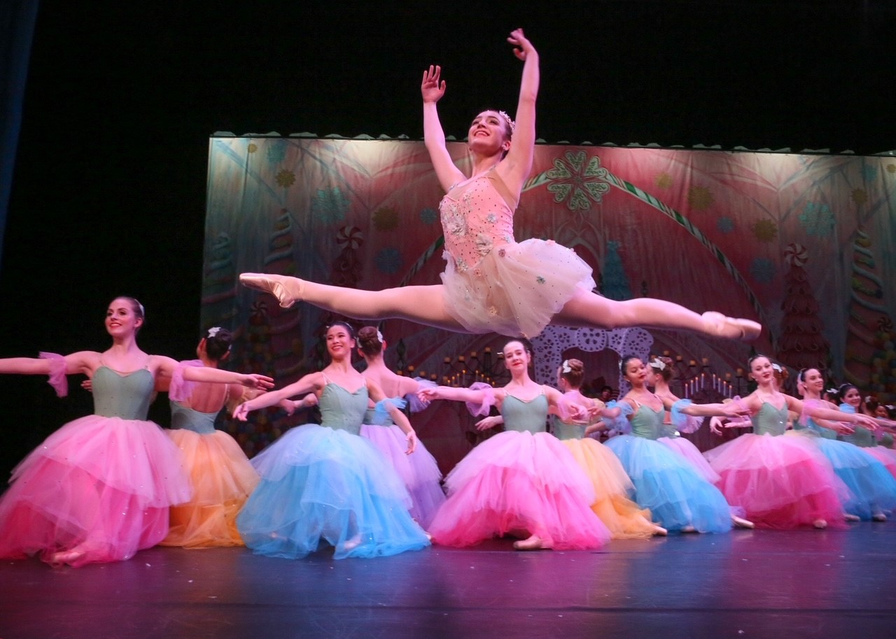 teenage girl in ballet costume doing splits in the air