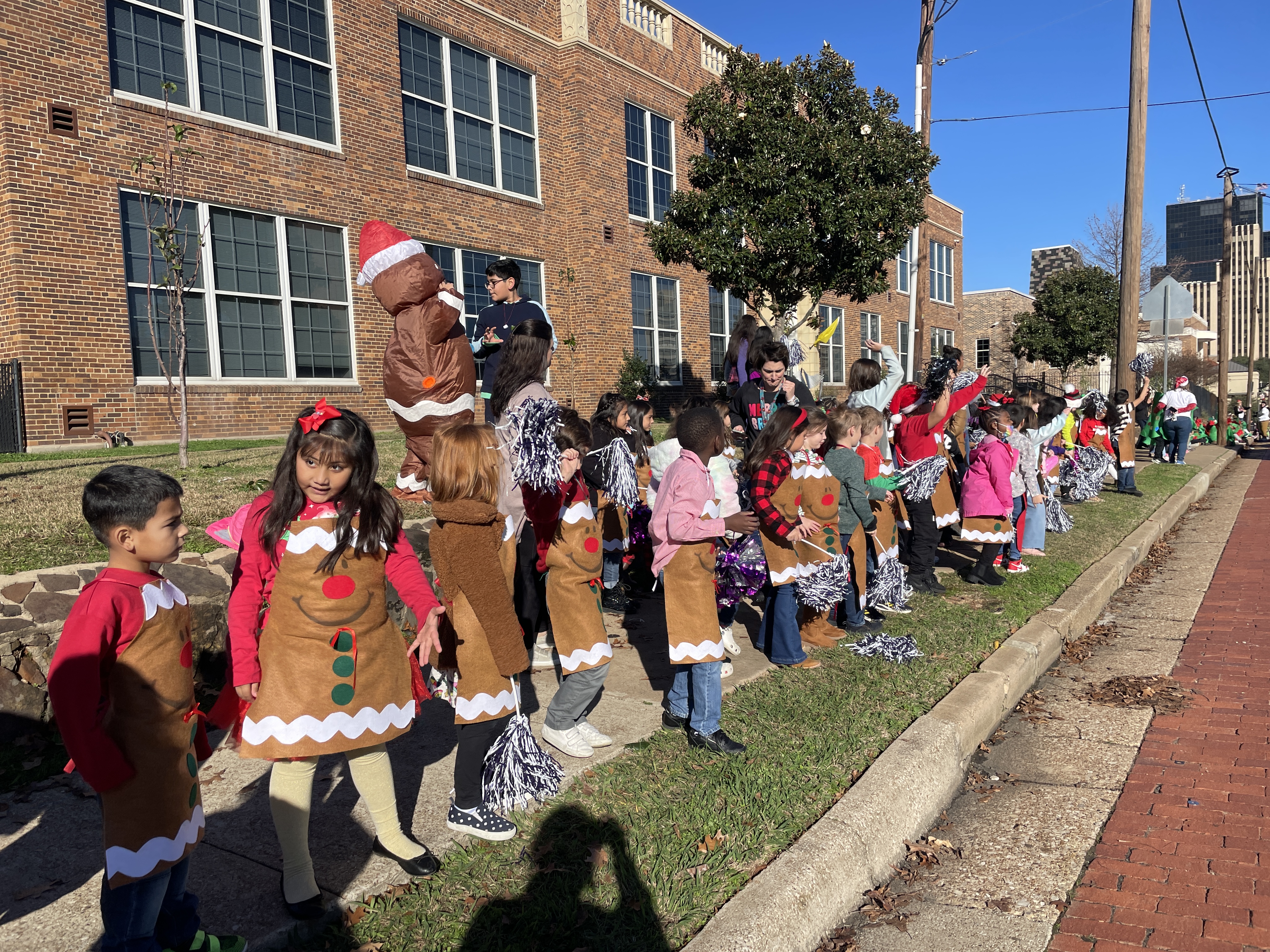 children along the sidewalk dressed in Christmas attire