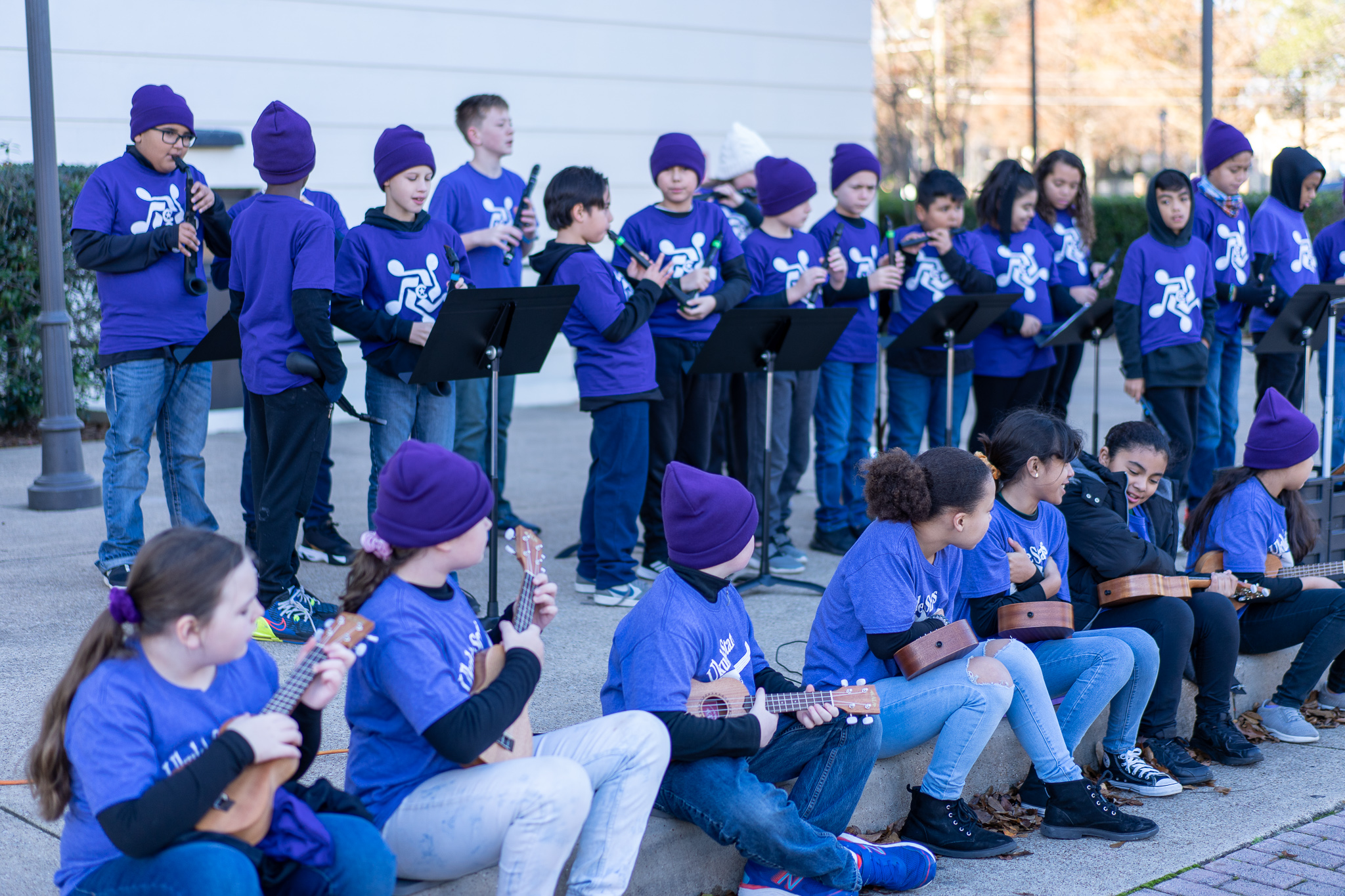 children wearing purple shirts and toboggans playing instruments 