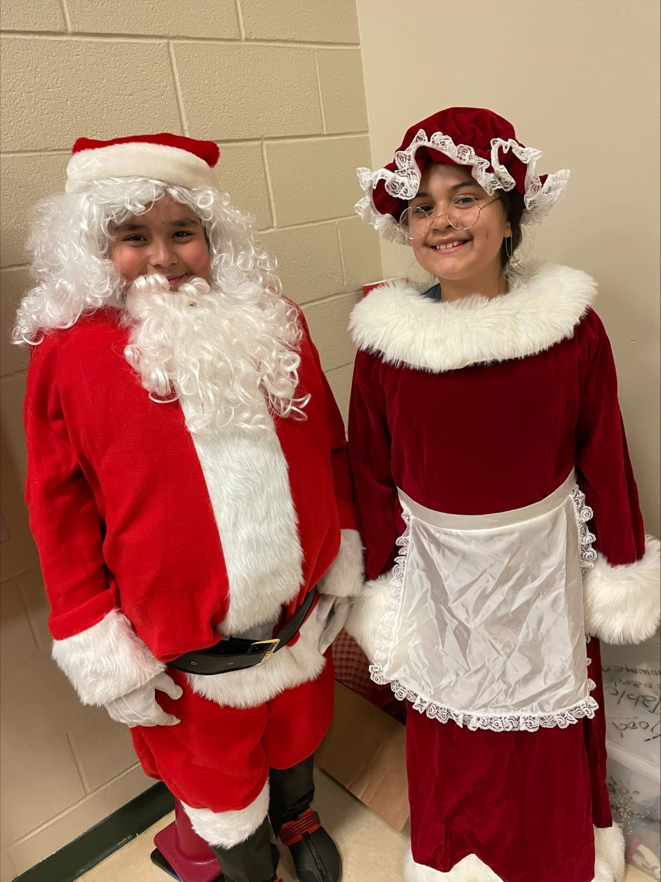 elementary aged boy and girl dressed as Mr. and Mrs. Claus