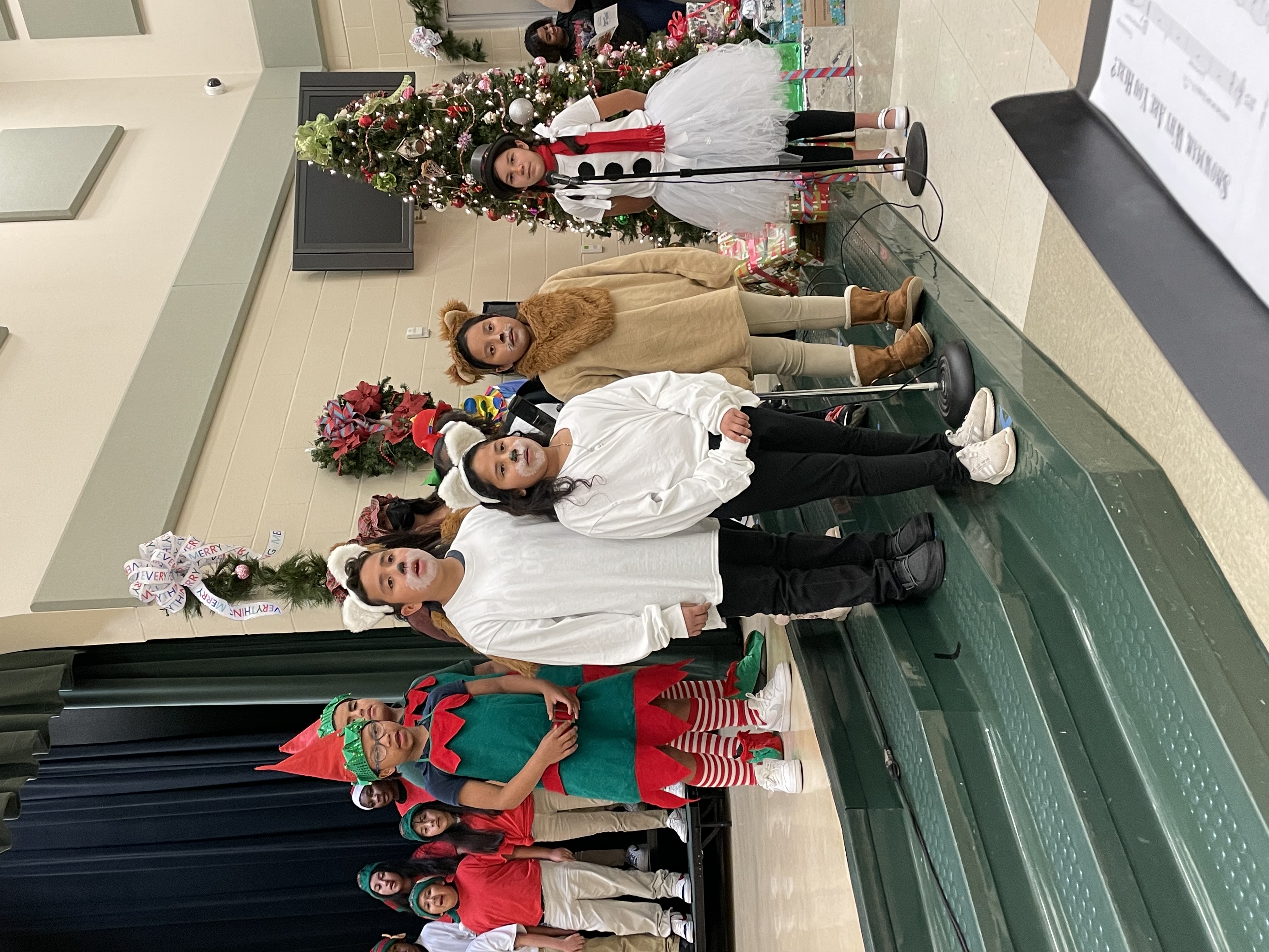 elementary aged kids dressed as reindeer, elves and Frosty the snowman