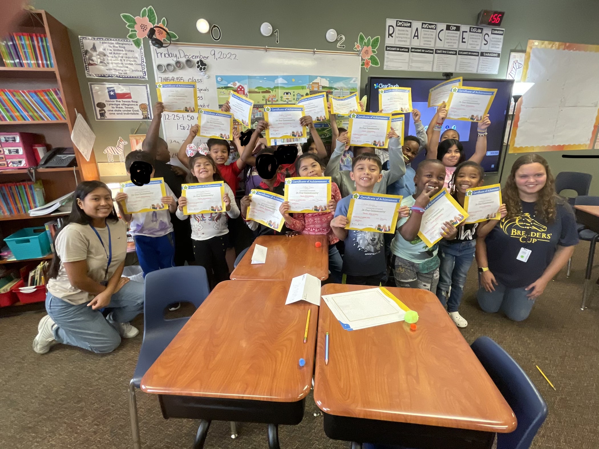 elementary aged students holding up certificates