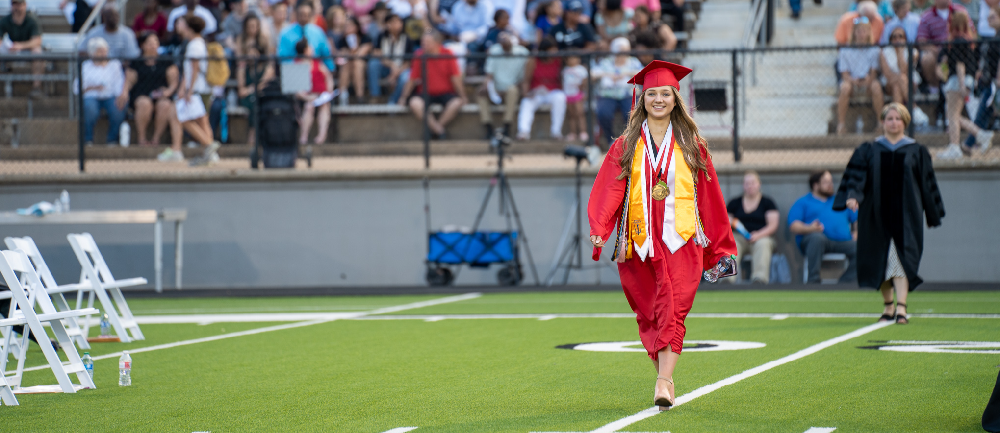 student walking on turf at graduation