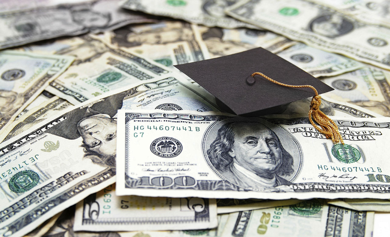 college graduation cap on money