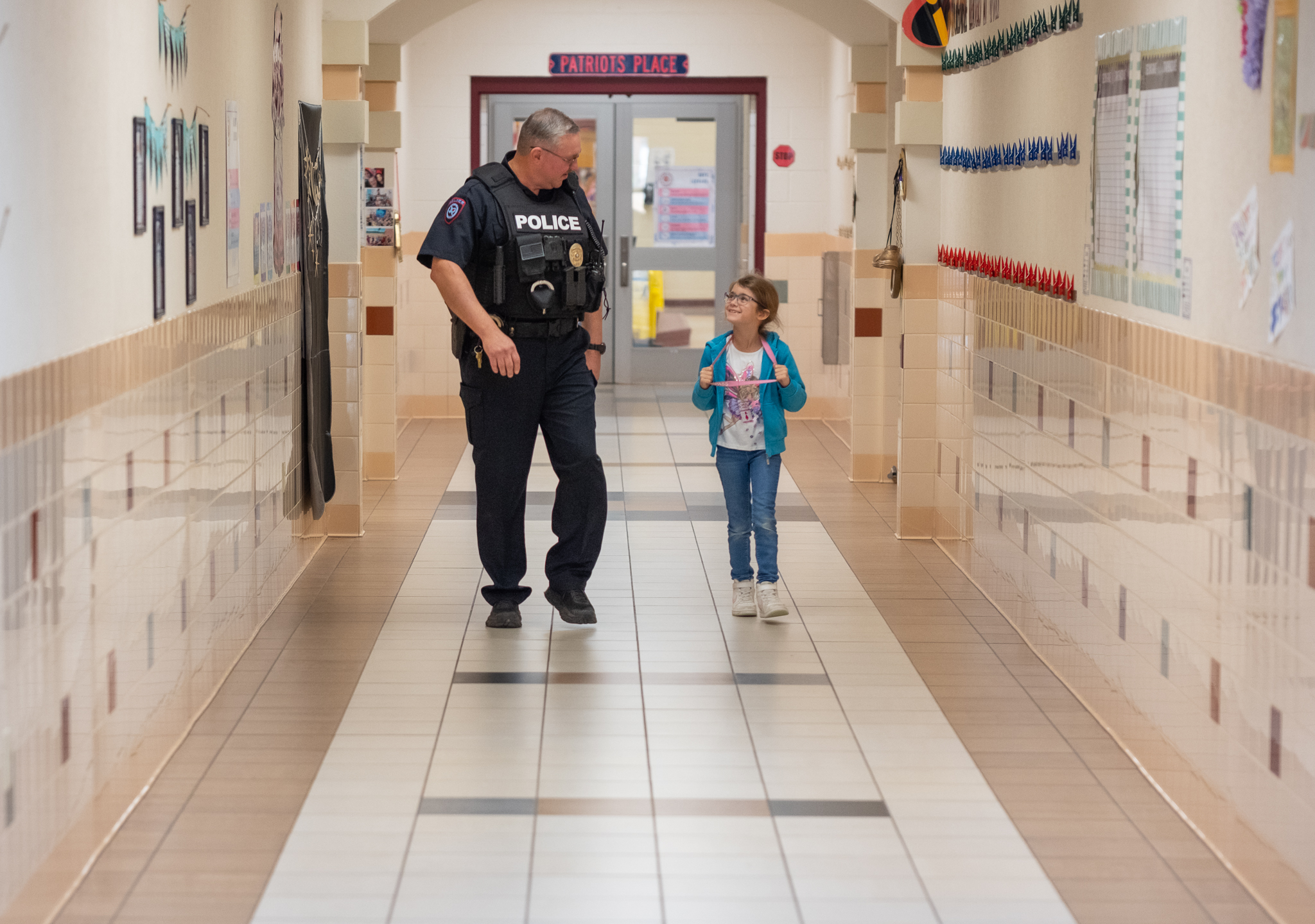 student walking with officer