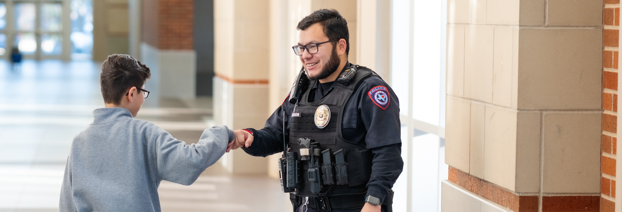 student fist bumping officer