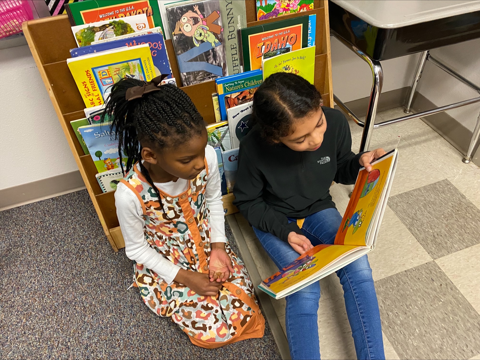 two elementary age girls reading a book