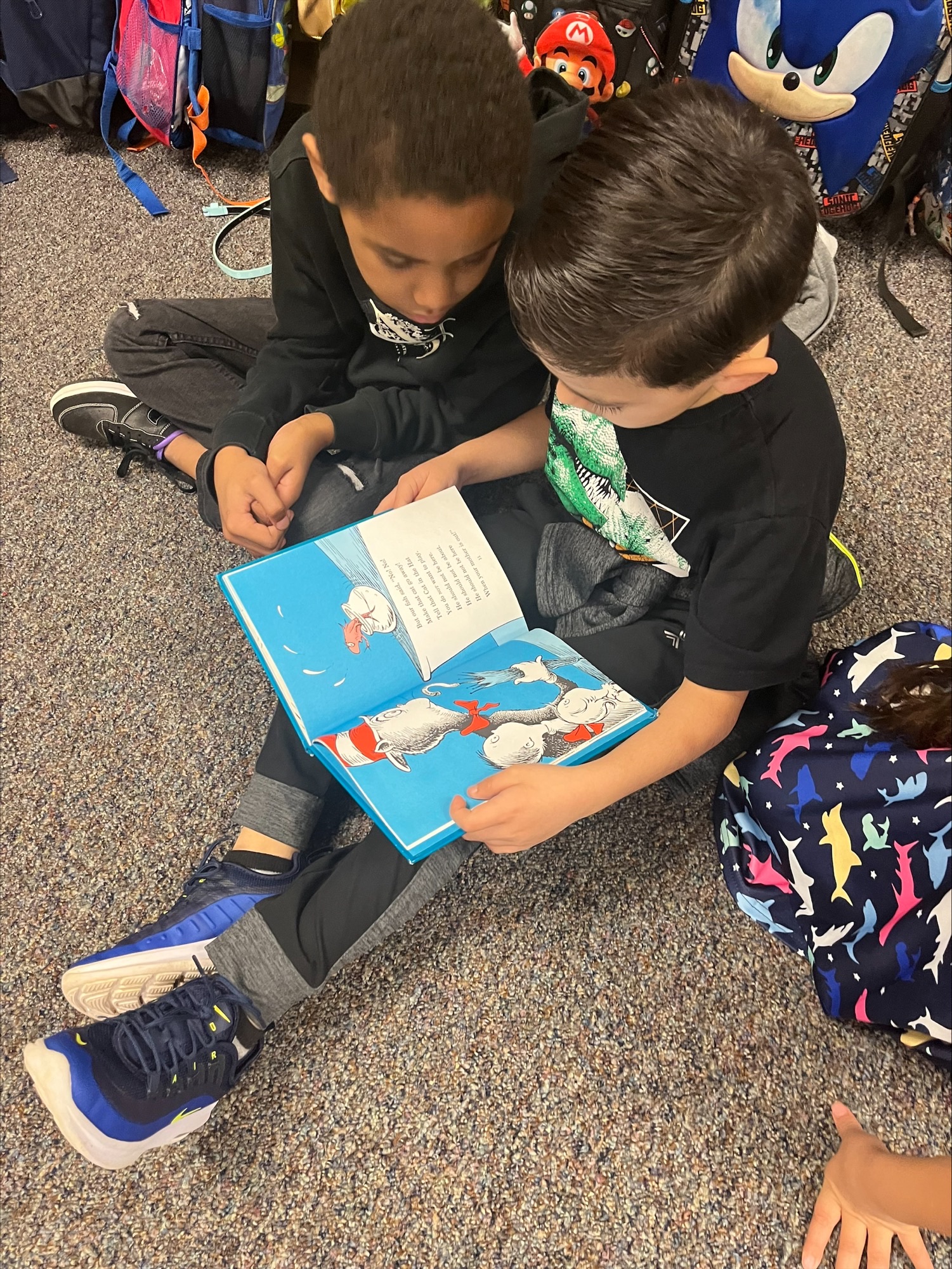 two elementary age kids reading a book