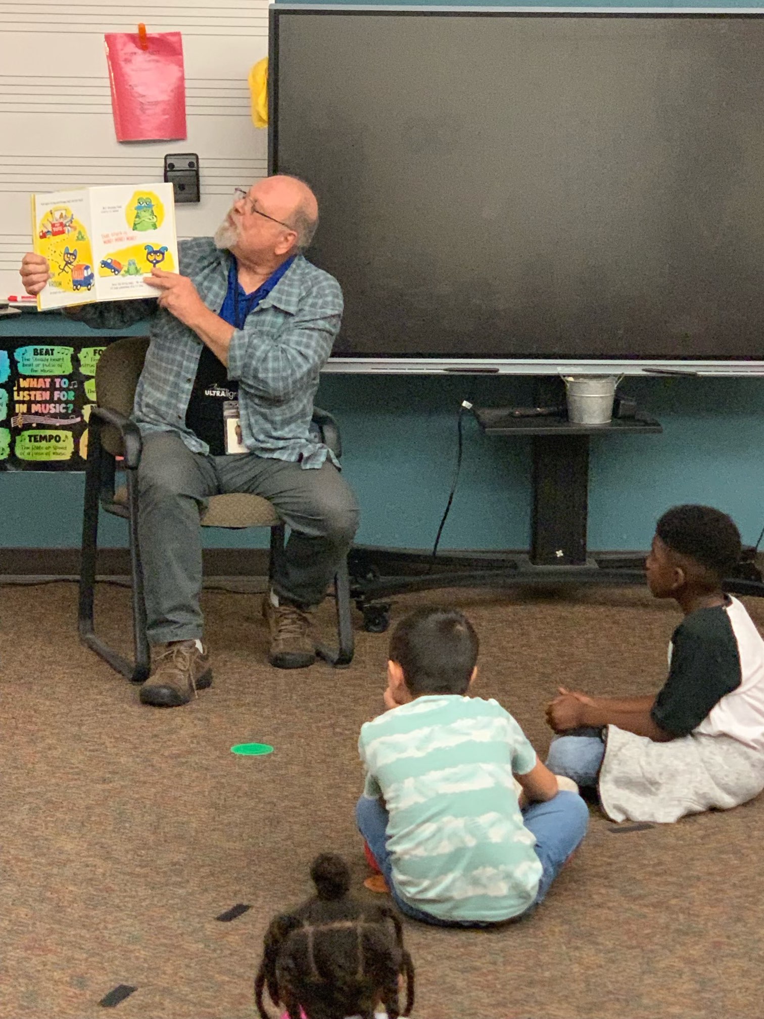 man reading a book to kids