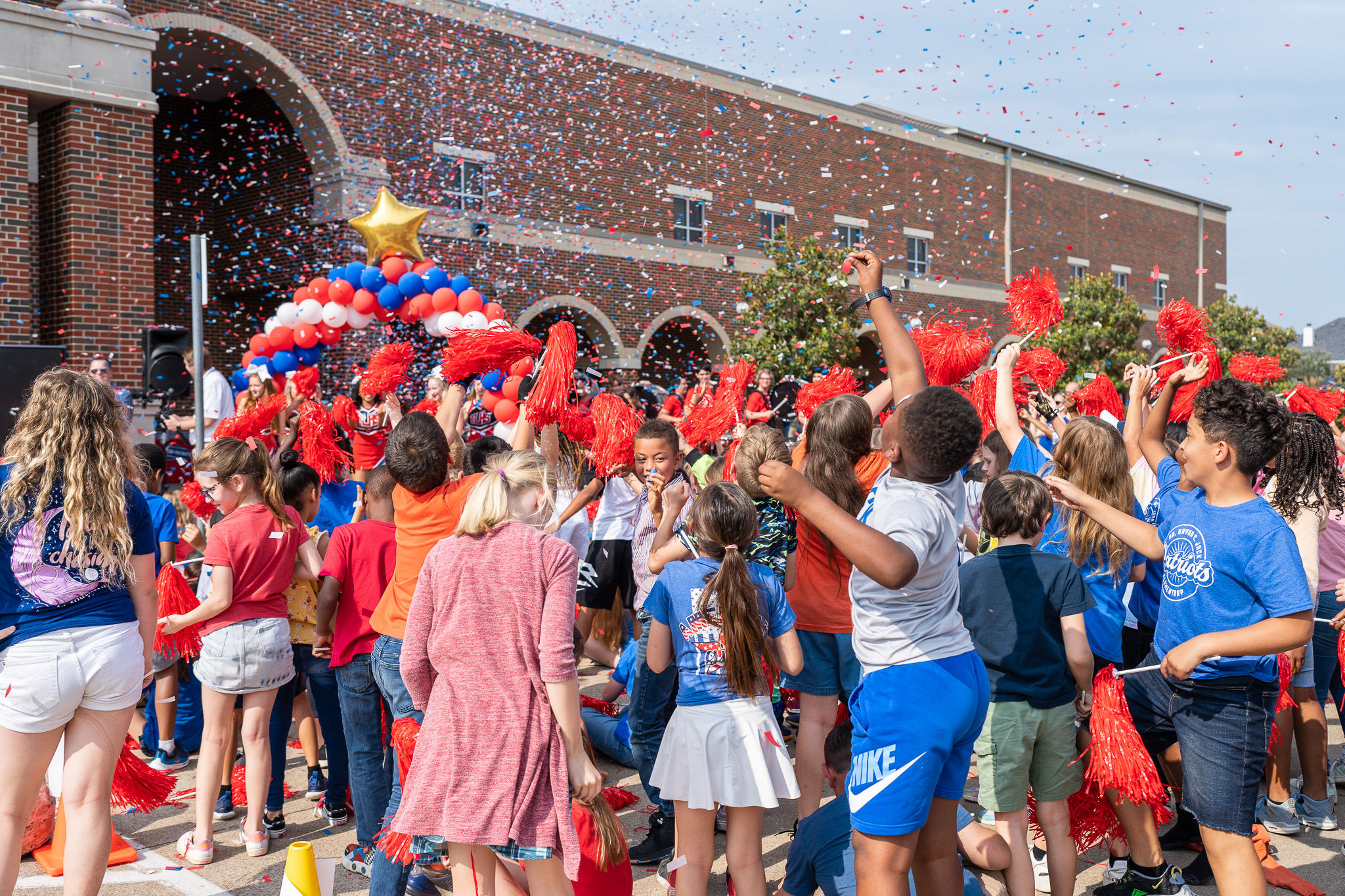 group of elementary students celebrating with confetti in the air