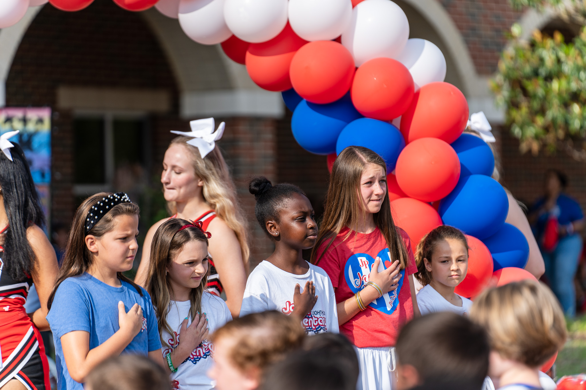 elementary age students standing with hands over hearts